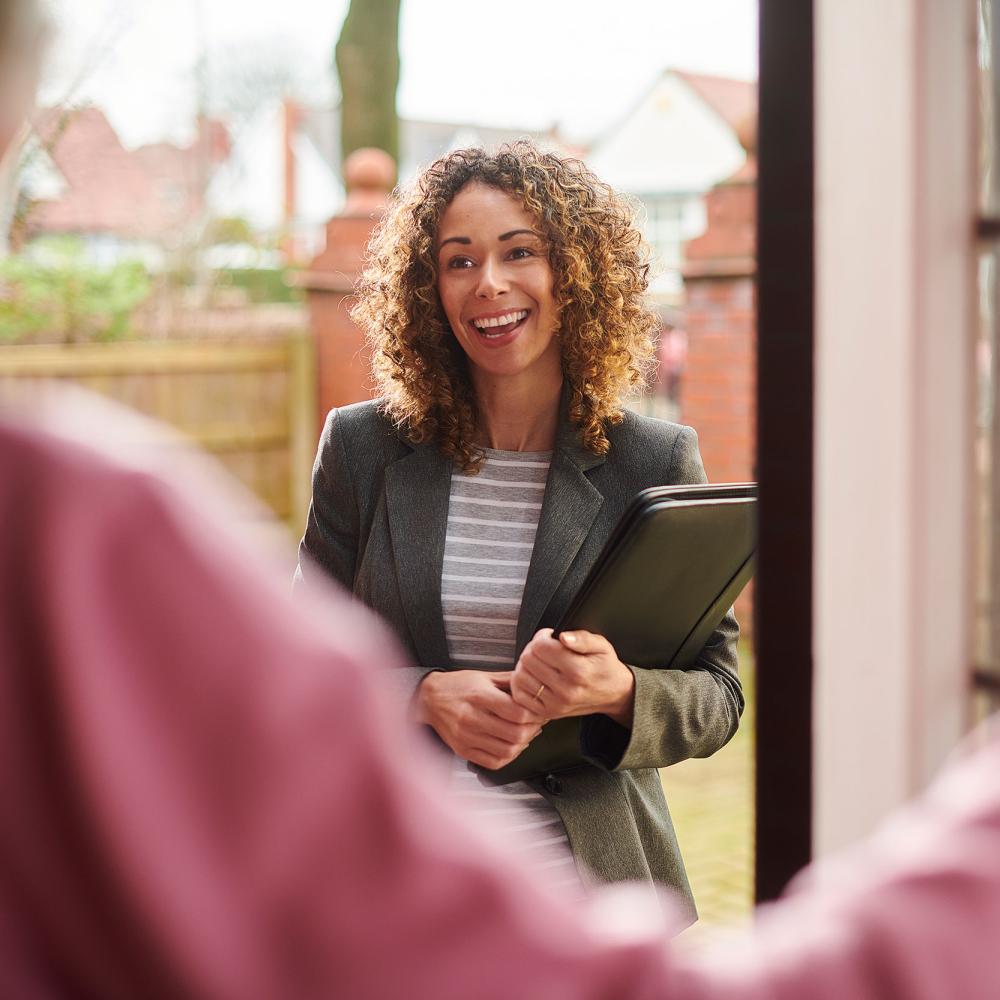 Social worker smiling by door