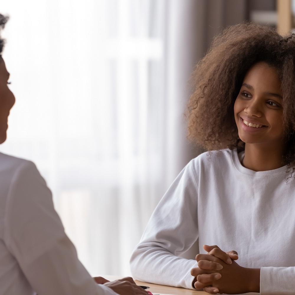 Teenage girl smiling at woman