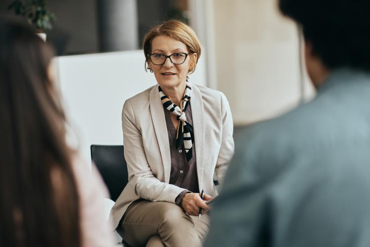 A woman speaking to two people