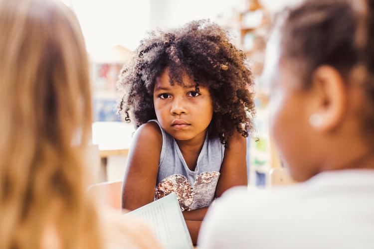 A young child looks across at two social work practitioners