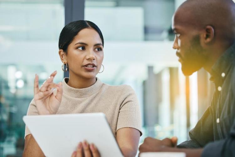 A woman discusses social work training topics with a man at a table