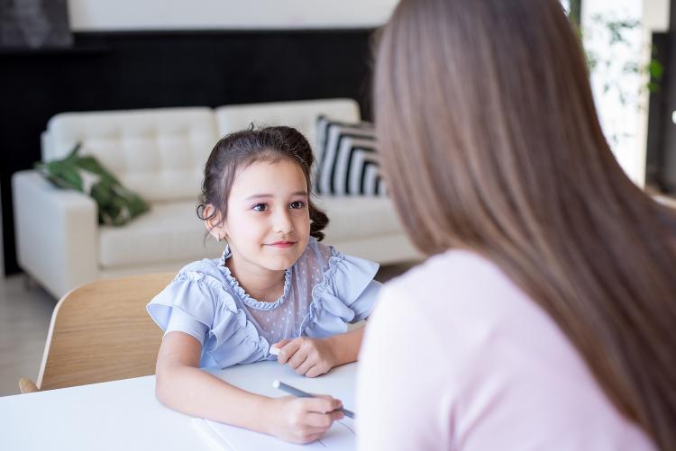 Young girl looking at a social worker across table