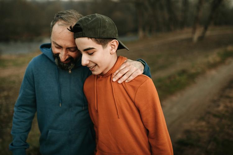 a man and young person smile while on a walk