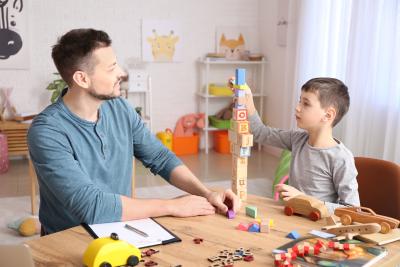 A man talks to a child and takes notes